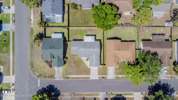 an aerial view of a houses with a yard