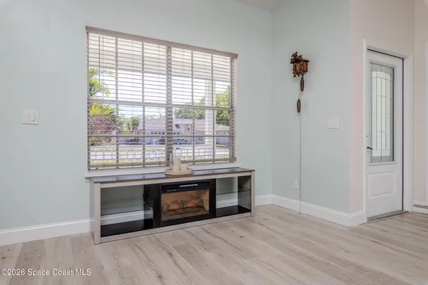 a kitchen with granite countertop a refrigerator a stove a sink dishwasher a oven with white cabinets and wooden floor