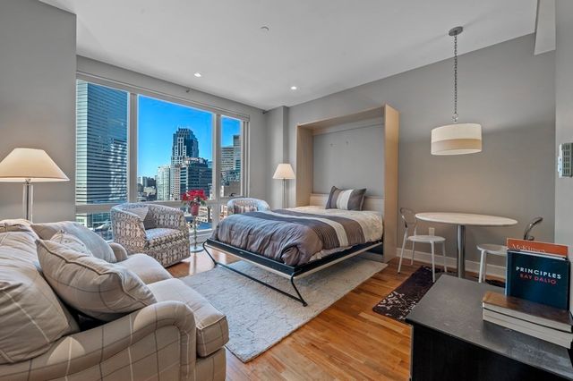 a spacious bedroom with a bed a table and a potted plant