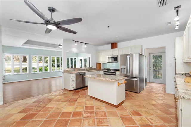 a kitchen with stainless steel appliances a stove a refrigerator cabinets a sink and a counter top space