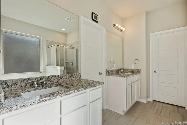 a bathroom with a granite countertop sink and a mirror