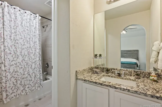 a bathroom with a granite countertop sink and a mirror