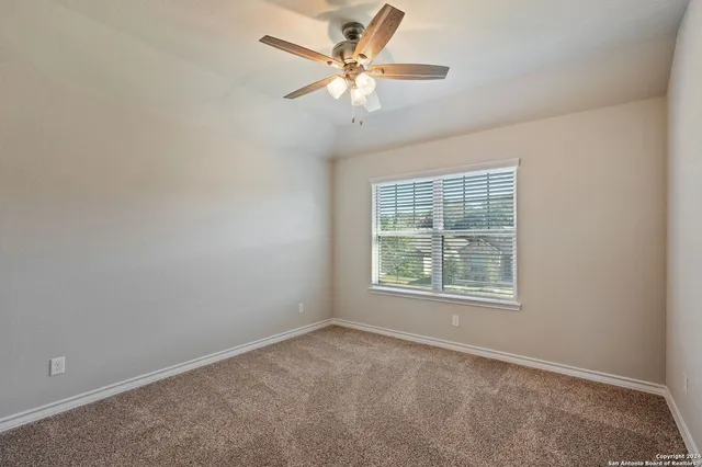 an empty room with a window and a fan