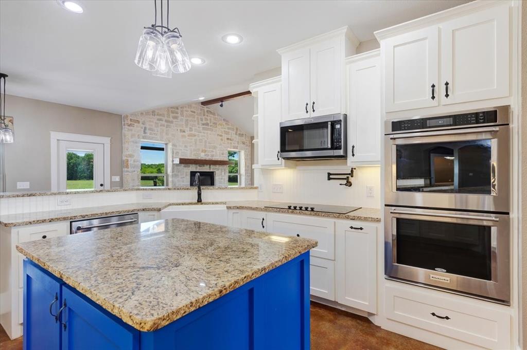 516 Springtown Road Van Alstyne, TX 75495 - Photo 13 of 40 a kitchen with stainless steel appliances granite countertop a stove microwave and cabinets