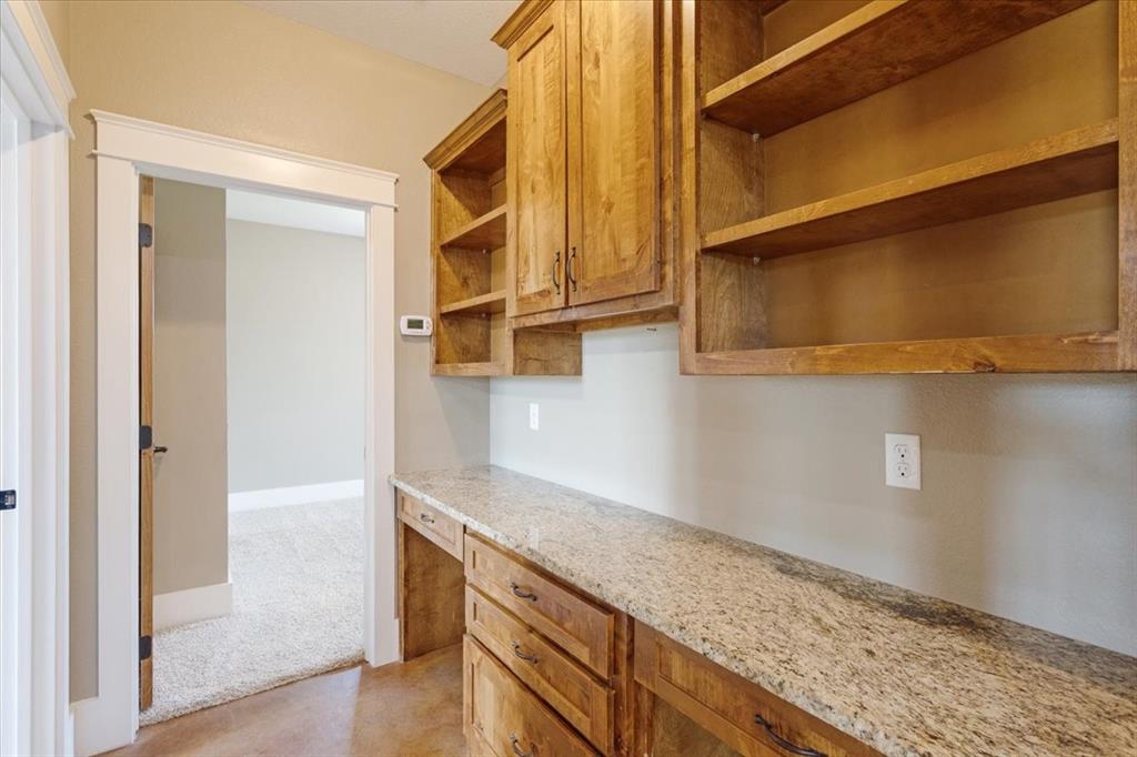 516 Springtown Road Van Alstyne, TX 75495 - Photo 27 of 40 a hallway with granite countertop white cabinets and a wooden floor