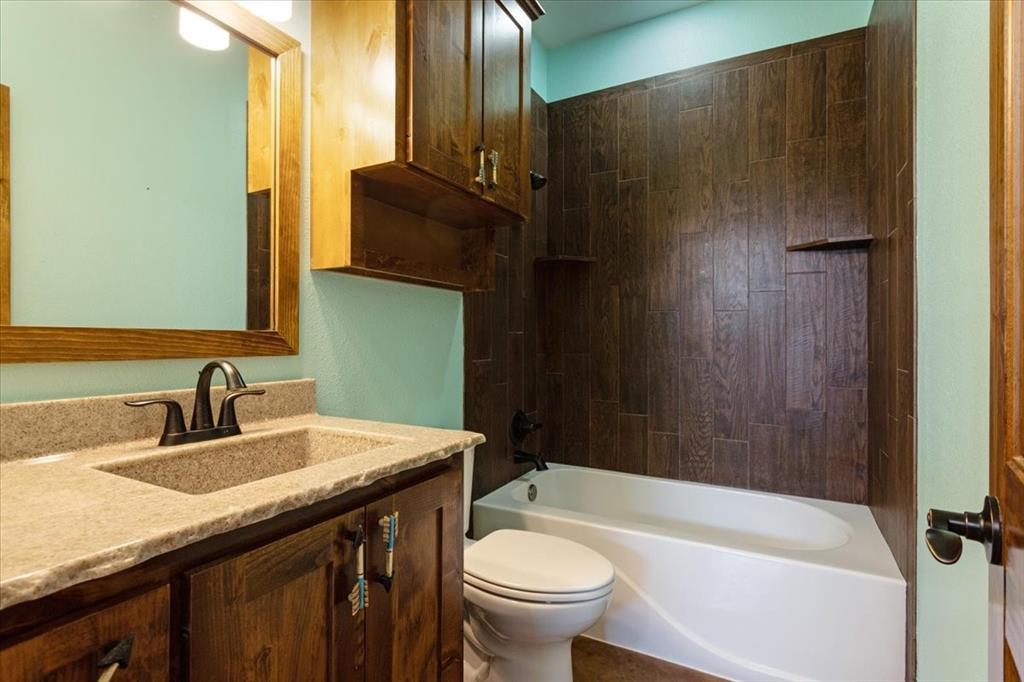 516 Springtown Road Van Alstyne, TX 75495 - Photo 29 of 40 a bathroom with a granite countertop sink toilet and shower
