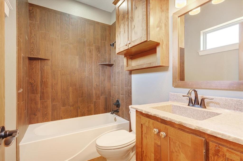 516 Springtown Road Van Alstyne, TX 75495 - Photo 31 of 40 a bathroom with a granite countertop sink toilet and shower