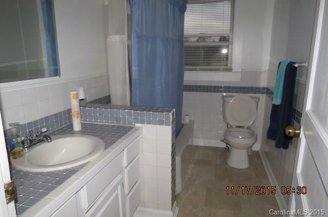 4020 Polk County Line Road Rutherfordton, NC 28139 - Photo 16 of 18 a bathroom with a granite countertop toilet sink and mirror