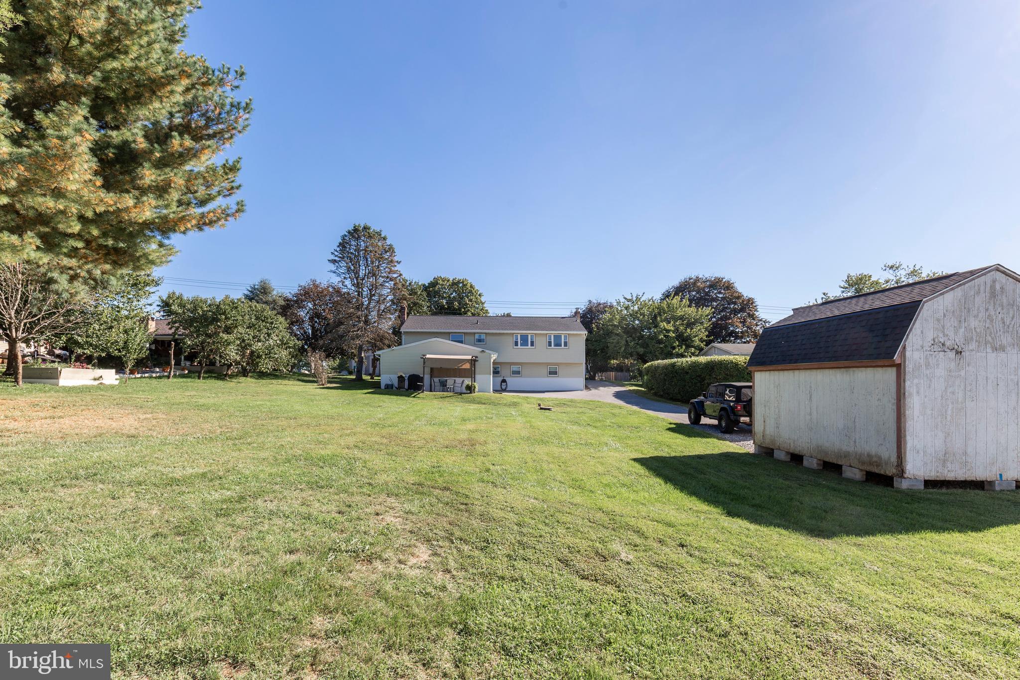 2108 Hanover Pike Hampstead, MD 21074 - Photo 41 of 51 a backyard of a house with table and chairs plants and large tree