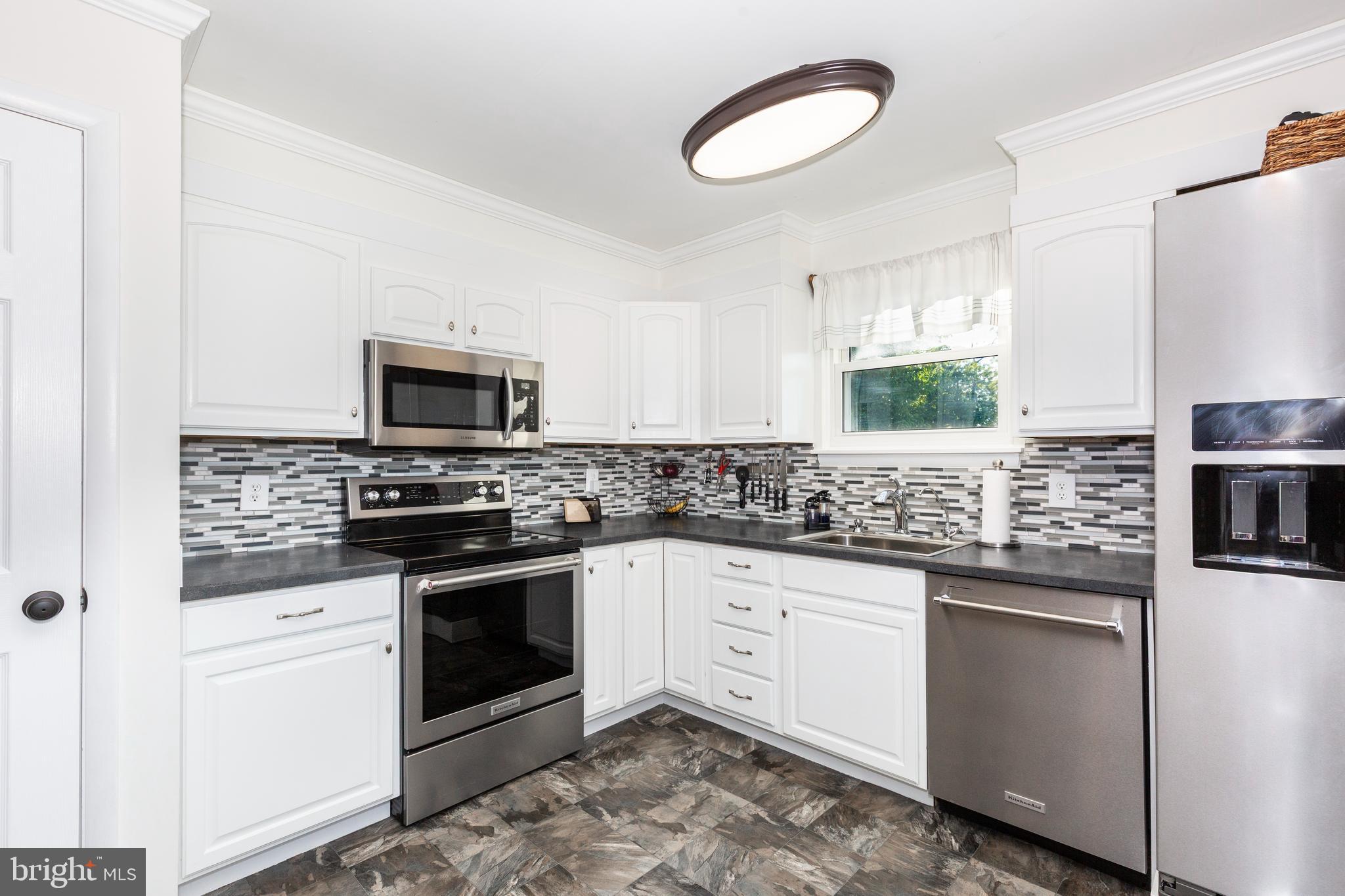 2108 Hanover Pike Hampstead, MD 21074 - Photo 10 of 51 a kitchen with granite countertop a sink stainless steel appliances and white cabinets