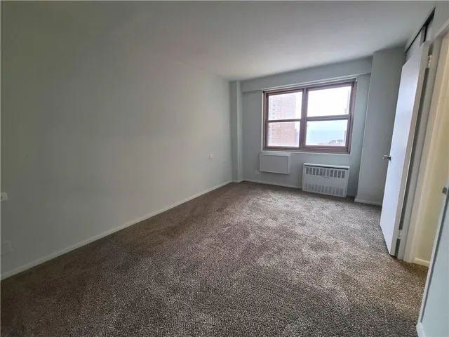 an empty room with a chair and a window