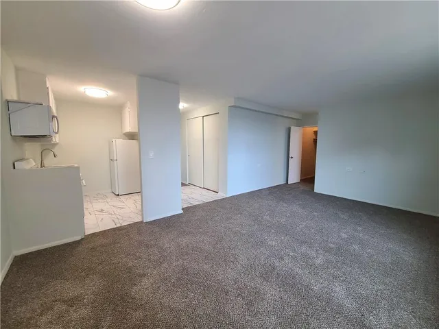 a view of a kitchen with a refrigerator and a sink