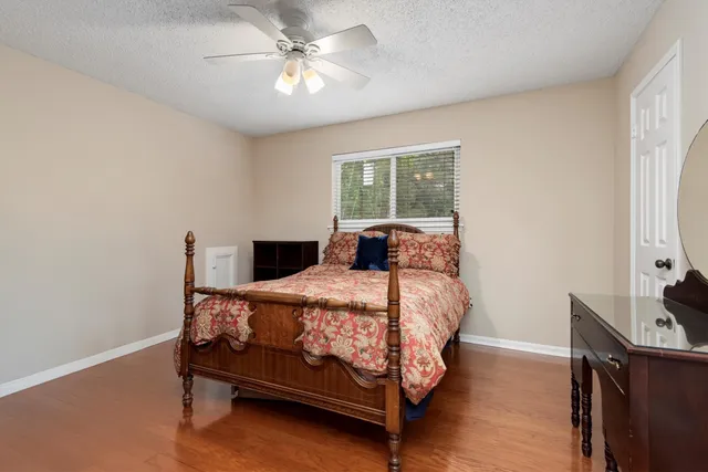 a bedroom with a bed chandelier and a window