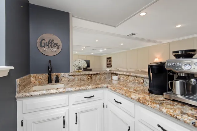 a kitchen with kitchen island granite countertop a sink a counter space and stainless steel appliances
