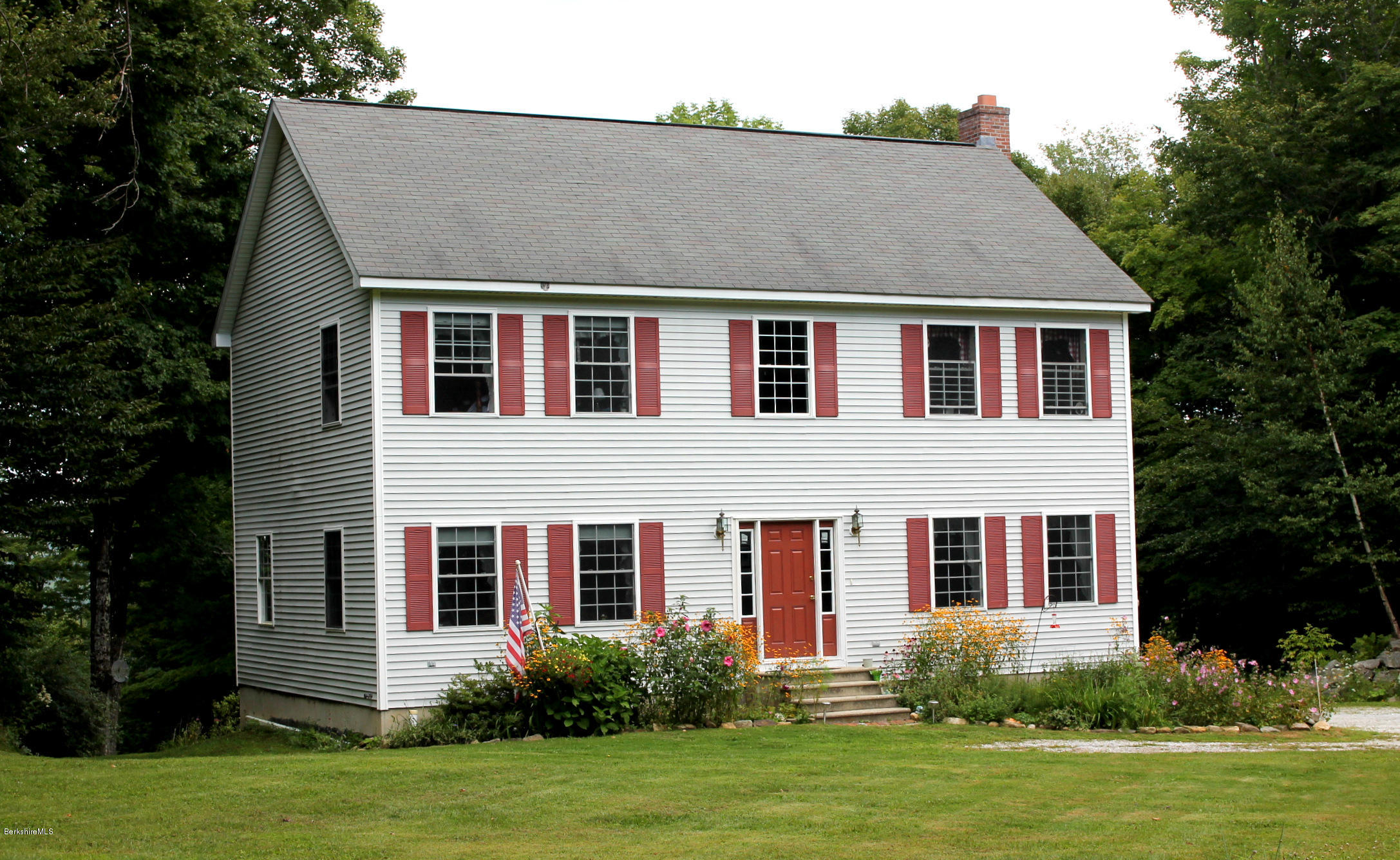 1006 West Center Road Otis, MA 01253 - Photo 1 of 22 a front view of a house with a yard and garage
