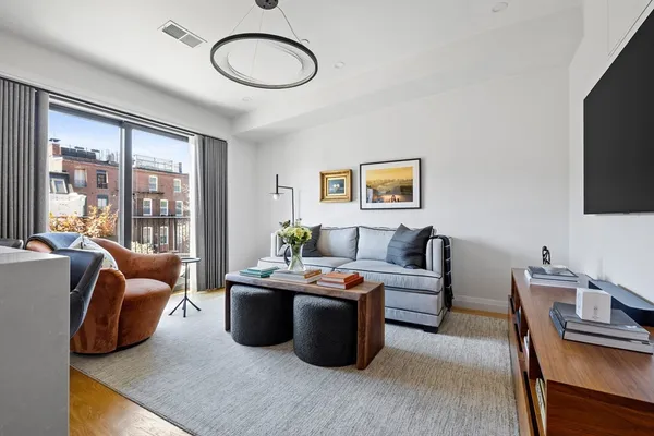 a living room with furniture a flat screen tv and a large window