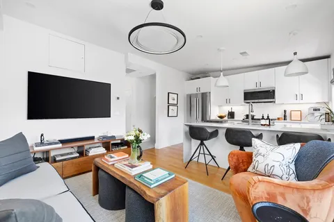 a living room with furniture kitchen view and a flat screen tv