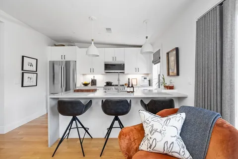 a kitchen with stainless steel appliances granite countertop a sink and a refrigerator