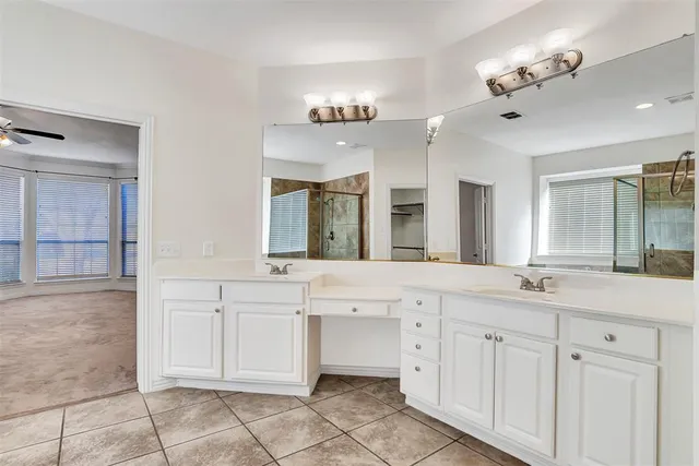 a large white kitchen with a sink and chandelier
