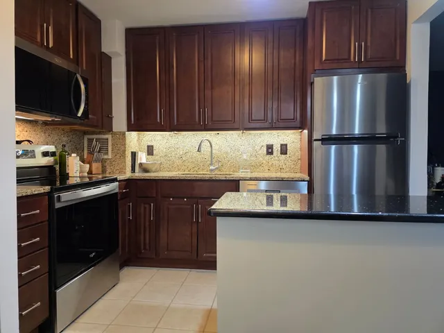 a kitchen with stainless steel appliances granite countertop a refrigerator and a sink