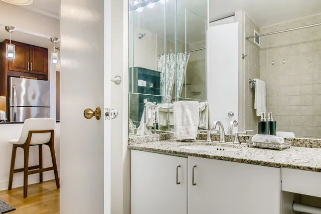 a bathroom with a granite countertop sink and a mirror