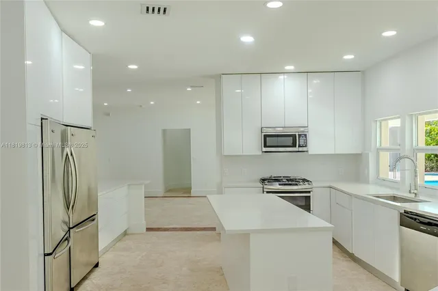 a kitchen with stainless steel appliances a refrigerator stove microwave and sink