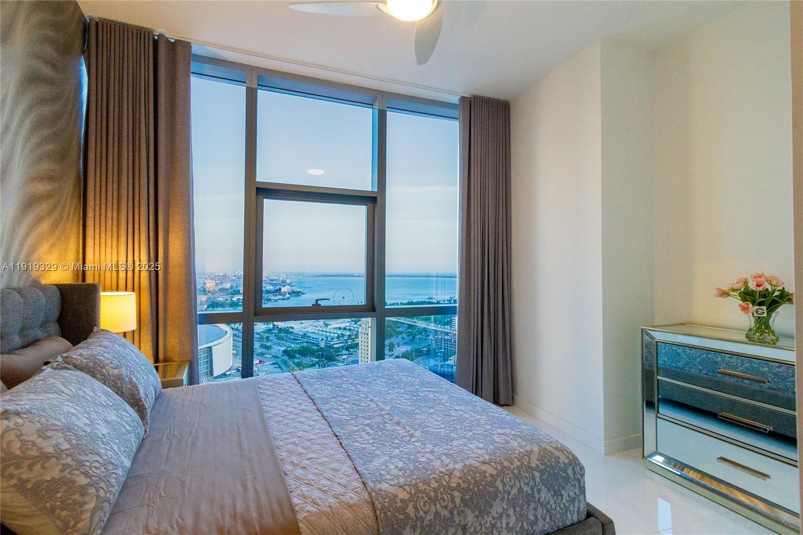 851 Northeast 1st Avenue, Unit 2811 Miami, FL 33132 - Photo 3 of 9 a bedroom with a bed and large window