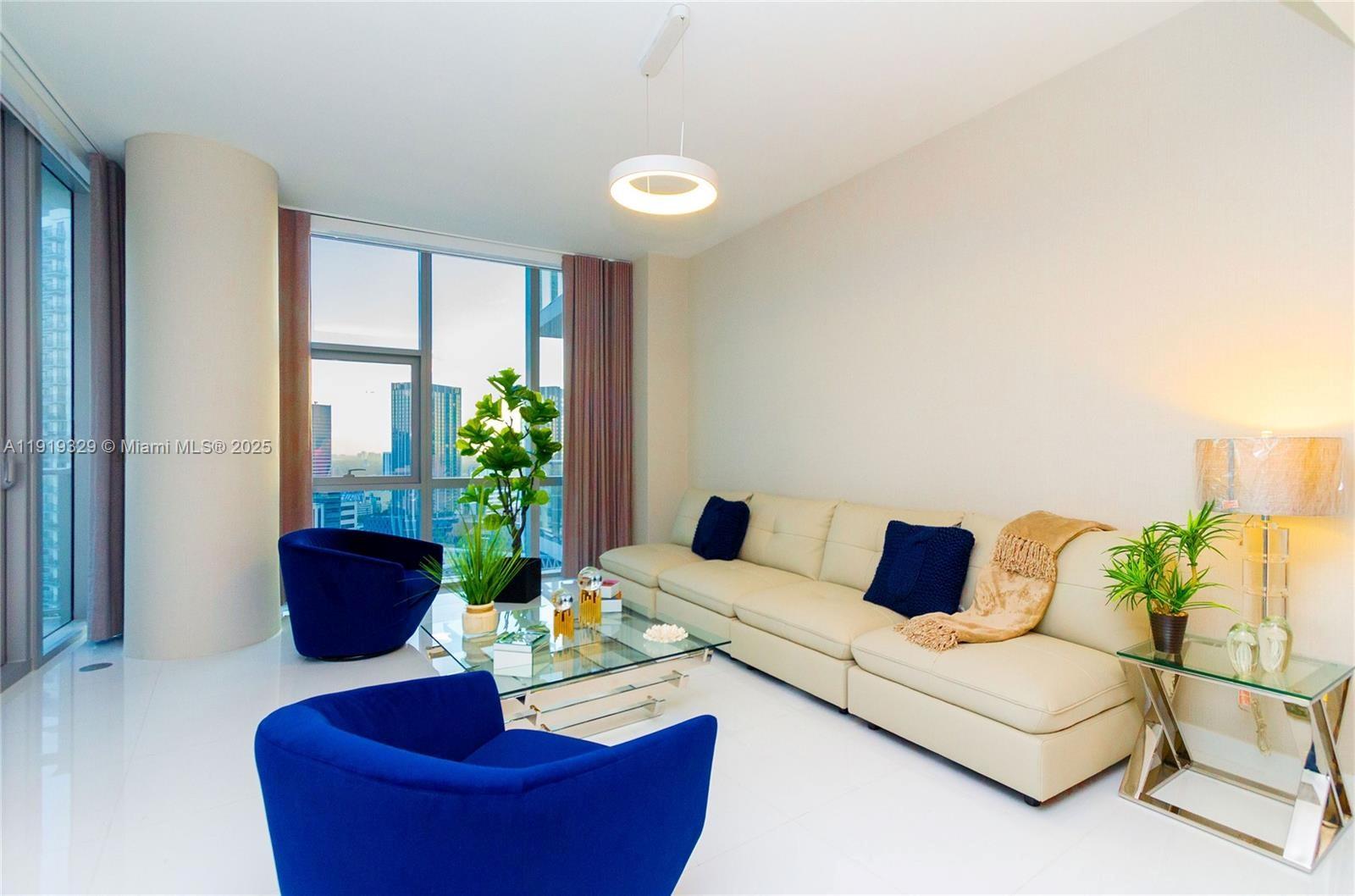 851 Northeast 1st Avenue, Unit 2811 Miami, FL 33132 - Photo 5 of 9 a living room with furniture and a potted plant