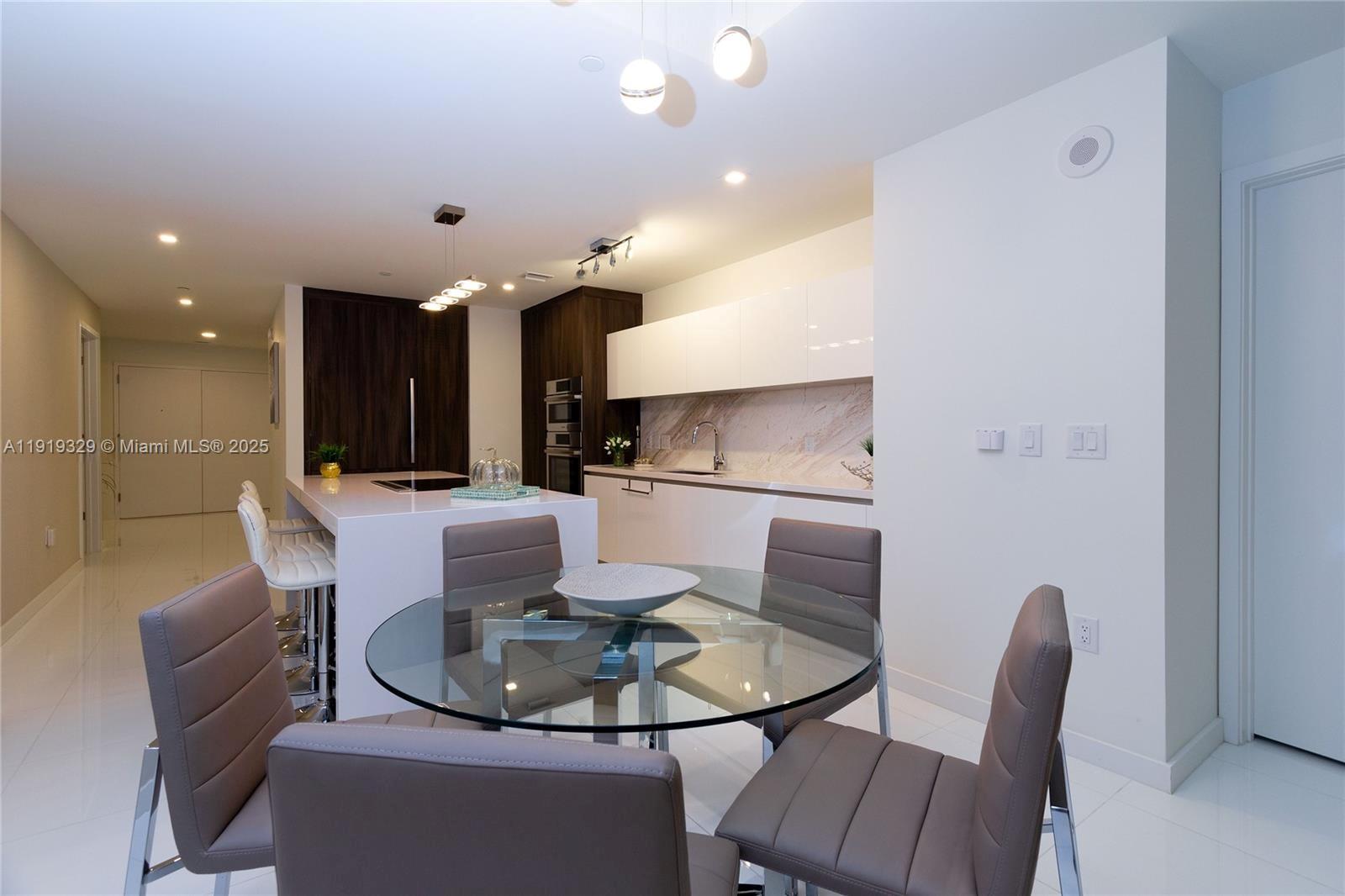 851 Northeast 1st Avenue, Unit 2811 Miami, FL 33132 - Photo 9 of 9 a dining room with furniture and a view of kitchen