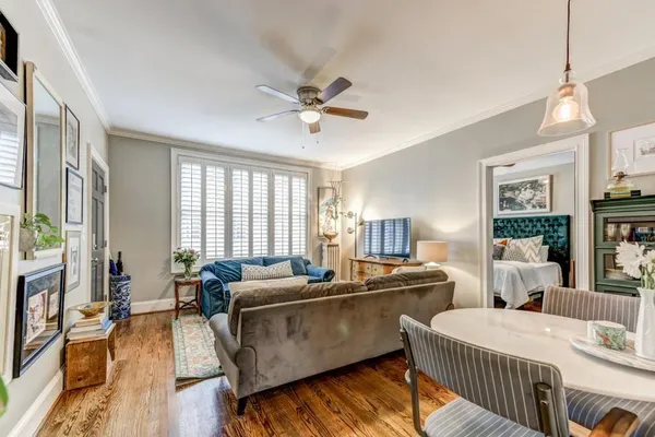 a living room with two couches a table and chairs with wooden floor