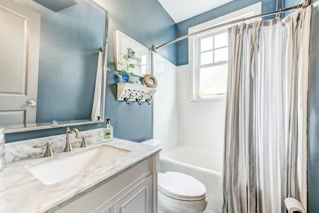 a bathroom with a granite countertop sink a toilet and a bathtub