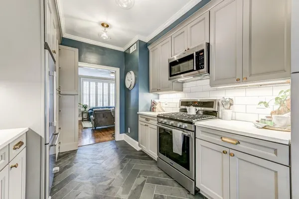 a kitchen with stainless steel appliances granite countertop a stove a refrigerator and a microwave