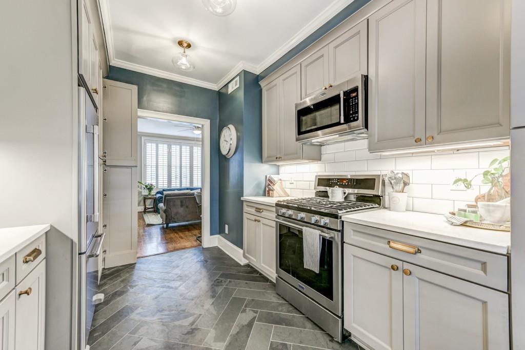 28 Collier Road Northwest, Unit 11 Atlanta, GA 30309 - Photo 5 of 23 a kitchen with stainless steel appliances granite countertop a stove a refrigerator and a microwave