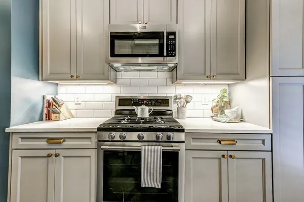 a stove top oven sitting inside of a kitchen