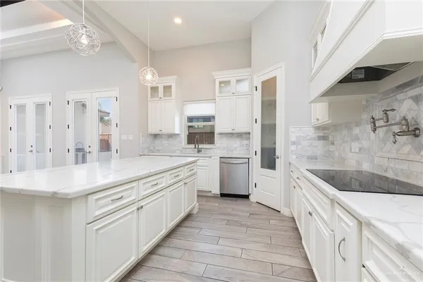 a kitchen with stainless steel appliances granite countertop a sink and dishwasher a stove with white countertops
