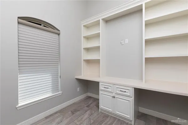 a kitchen with white cabinets and a window