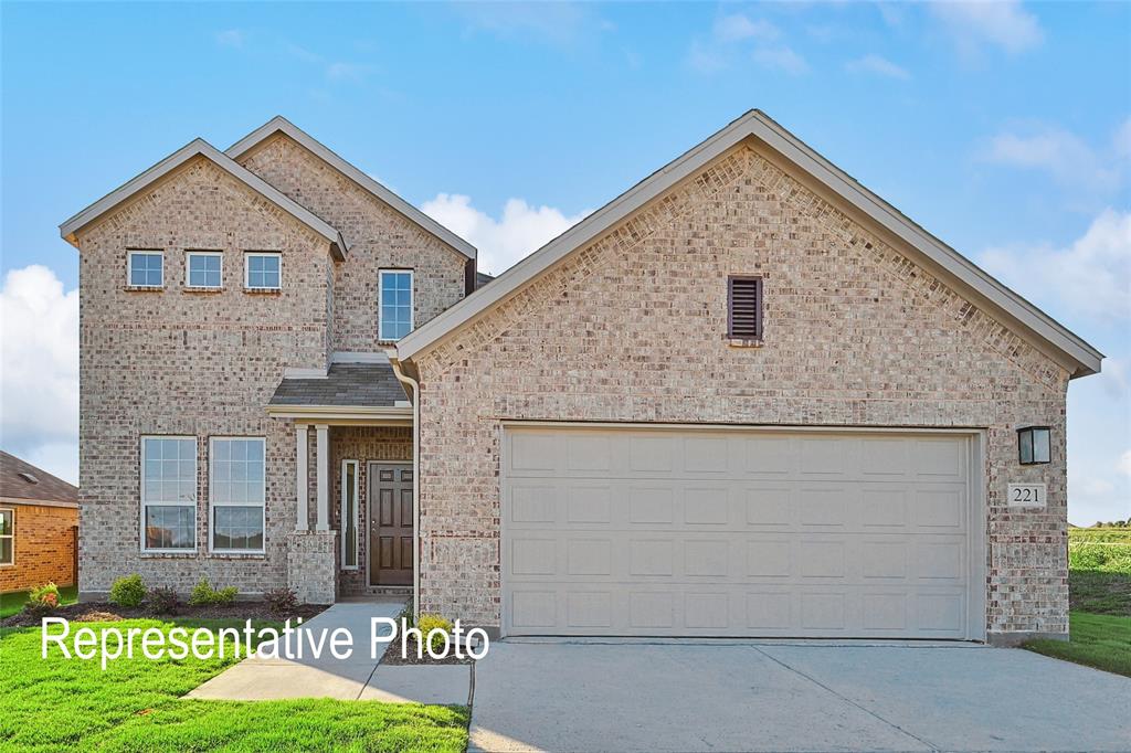 View of front of home featuring a garage, brick siding, and driveway