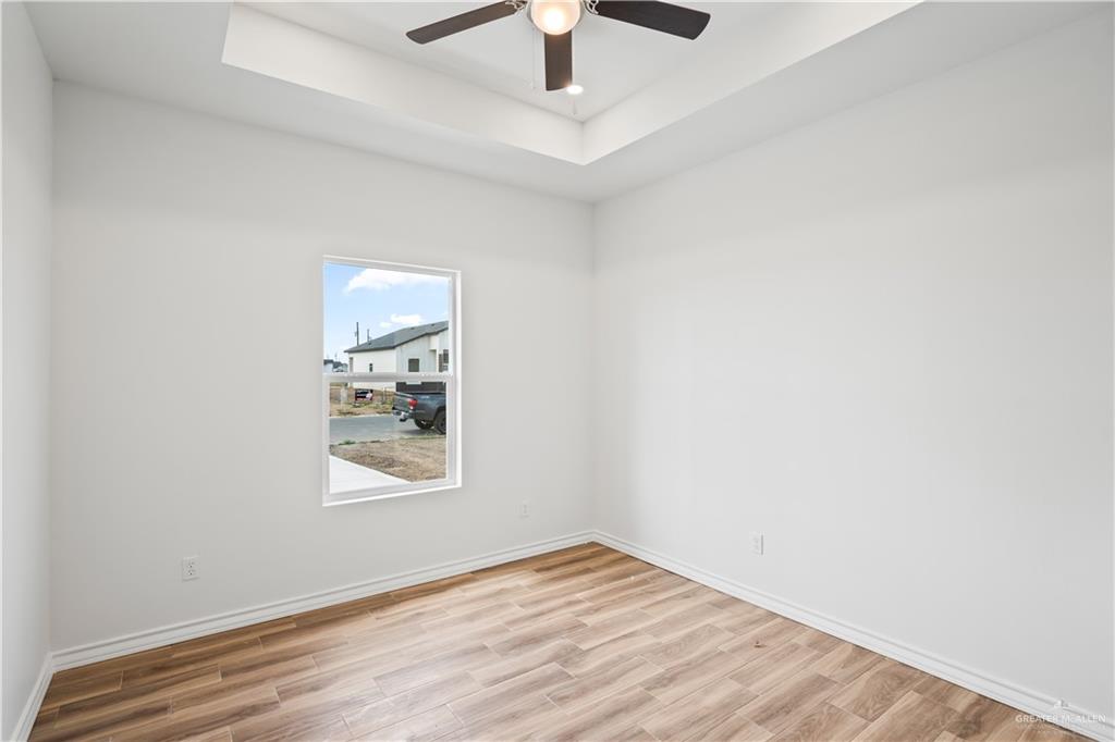 2317 Tuscany Road Weslaco, TX 78596 - Photo 7 of 13 an empty room with a window and a ceiling fan