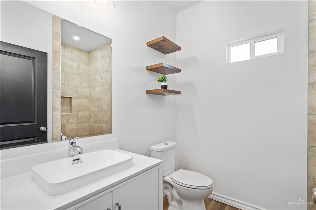 2317 Tuscany Road Weslaco, TX 78596 - Photo 10 of 13 a bathroom with a sink a toilet and a mirror