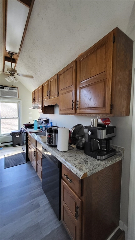 118 Gershom Avenue, Unit 3 Lowell, MA 01854 - Photo 2 of 9 a kitchen with granite countertop a stove top oven a sink dishwasher and cabinets with wooden floor