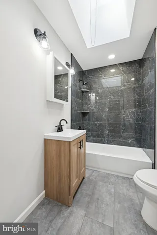 a spacious bathroom with a bathtub sink mirror and toilet