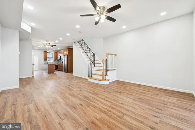 a view of a livingroom with a ceiling fan & hardwood floor