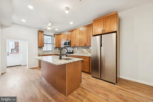 a kitchen with stainless steel appliances granite countertop a refrigerator a sink and a stove