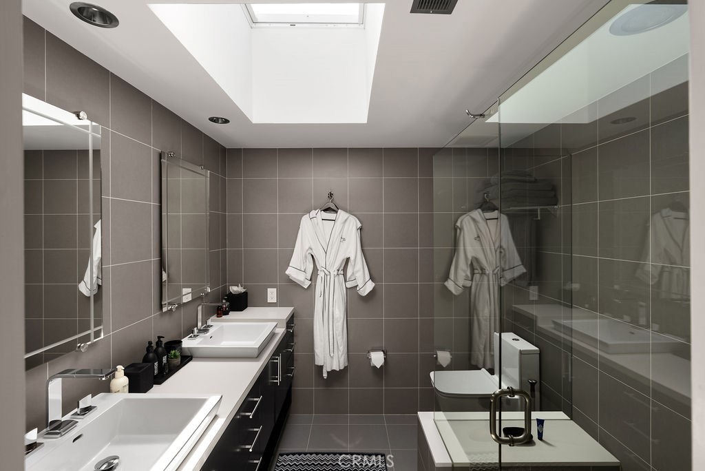 1585 South Coast Highway, Unit 66 Laguna Beach, CA 92651 - Photo 11 of 18 a bathroom with a double vanity sink and a mirror