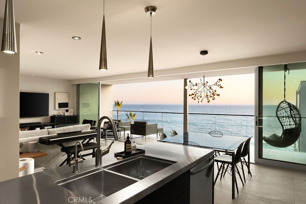1585 South Coast Highway, Unit 66 Laguna Beach, CA 92651 - Photo 5 of 18 a kitchen with a table chairs and flat screen tv