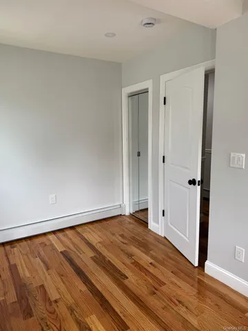 a view of a white house with large windows and a small yard