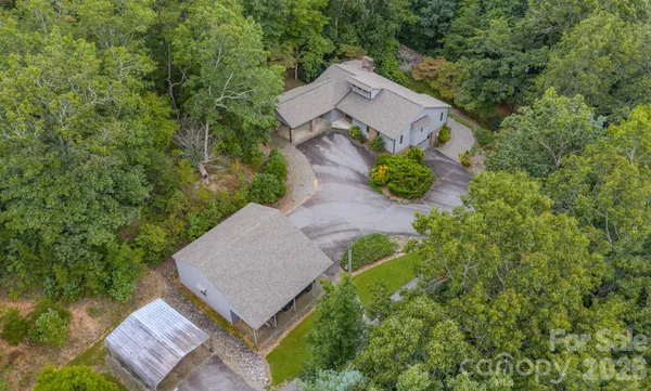 an aerial view of a house with a yard and large tree