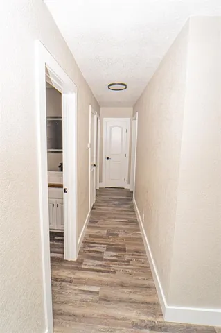 a view of a hallway with wooden floor and entryway