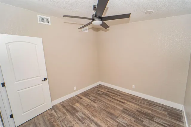 a view of a room with wooden floor and fan
