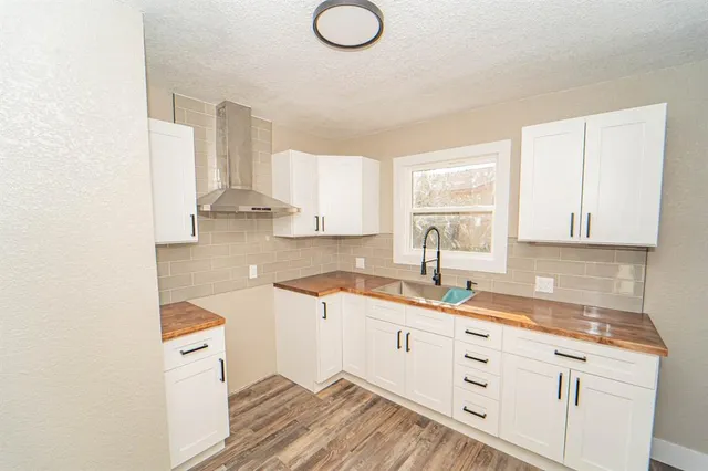 a kitchen with granite countertop a sink a stove and cabinets